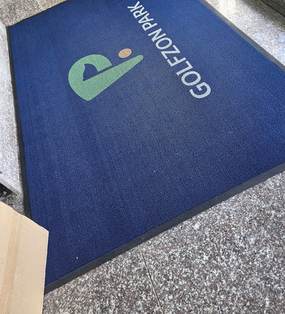 Loop 7 mm custom logo mat in navy blue with a green and white logo at a doorway, customer photo